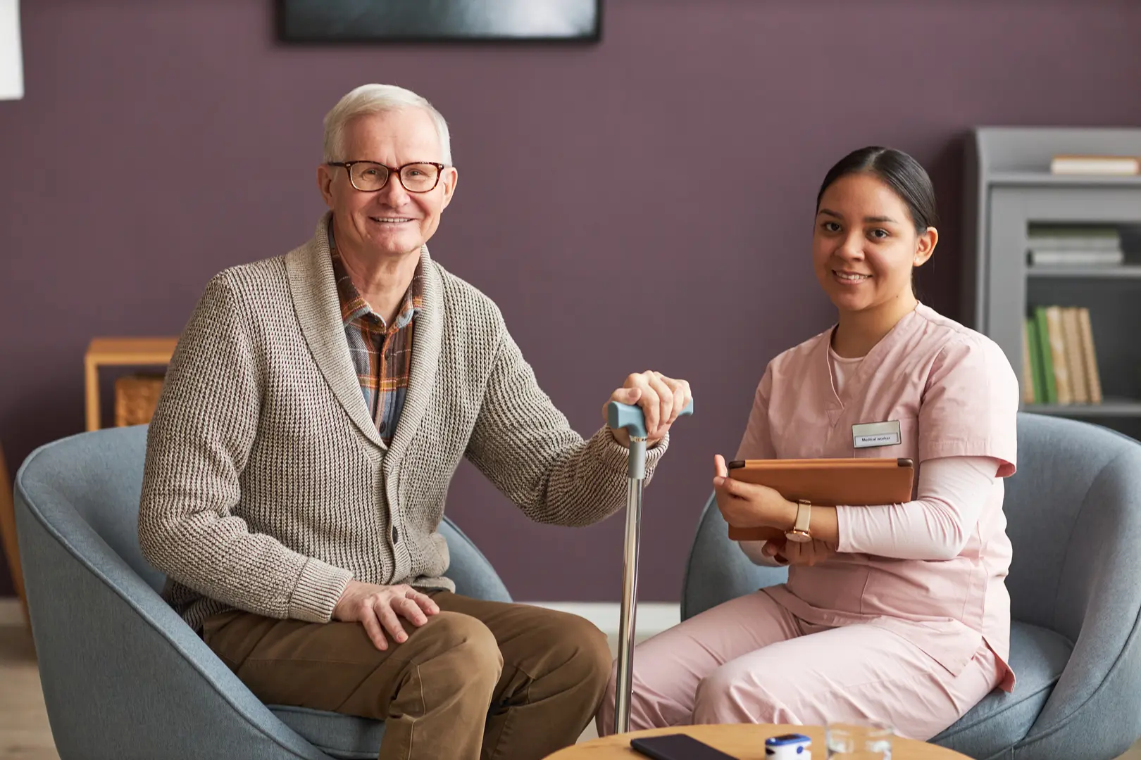 Acute Care Elderly Man Sitting With Worker
